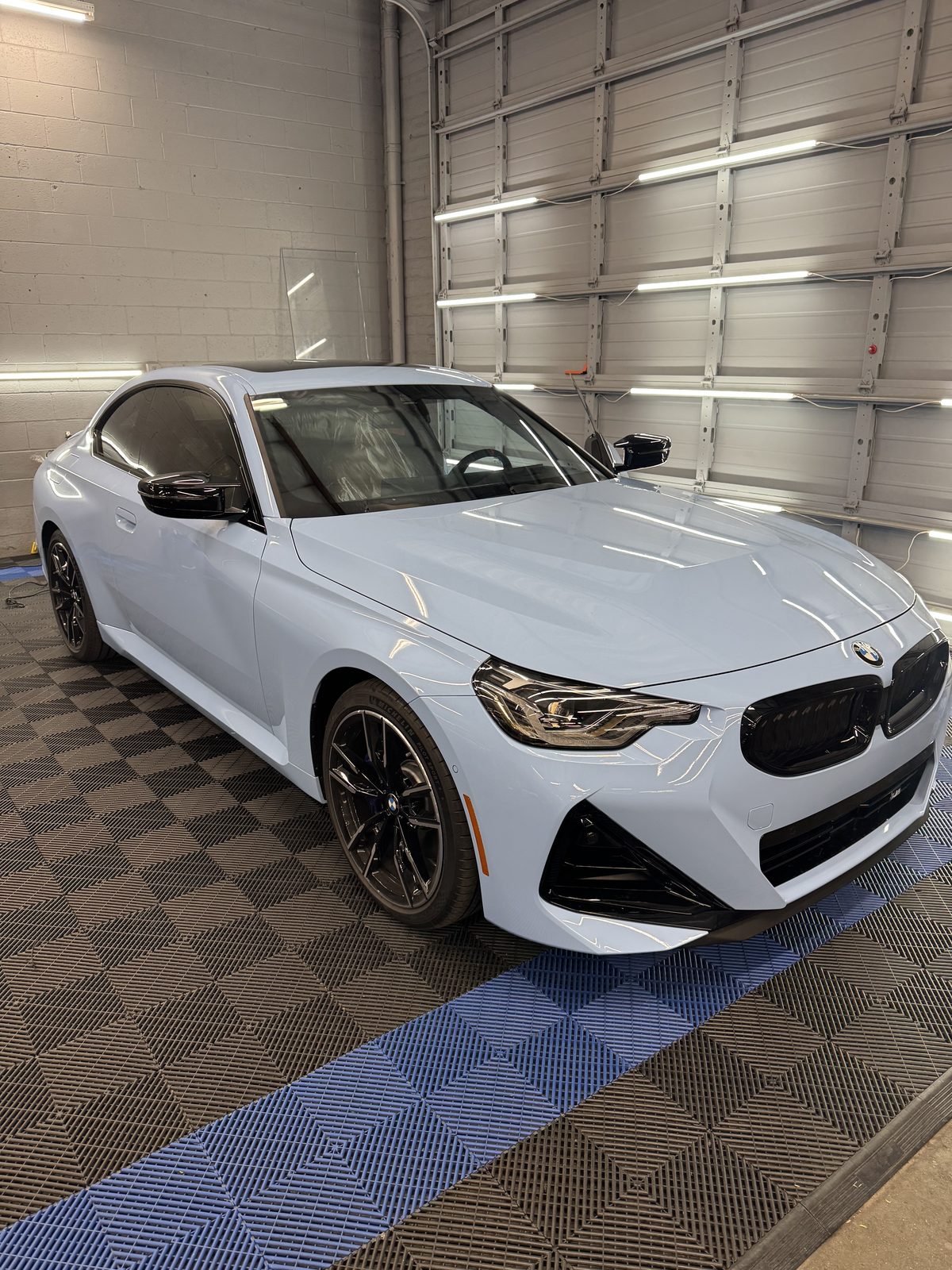 Light blue BMW M240i with dark ceramic tint