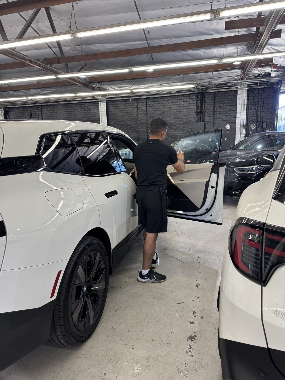 Installer fitting film on a BMW iX window